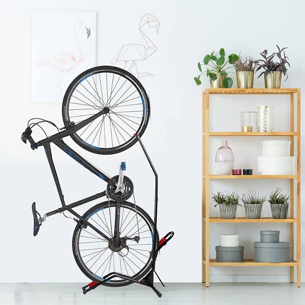 The vertical bike rack holding a bike upright beside a shelf in a bright room